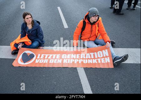 28.04.2023, Berlin, Deutschland, Europa - Klimaprotestierende der so genannten Letzten Generation (Letzte Generation) haben sich auf den Asphalt der Straße geklebt. Stockfoto