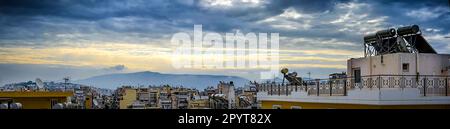 Piräus, Griechenland, Vogelblick über die Dächer bei Sonnenaufgang. Dramatischer Himmel über der Stadt Stockfoto