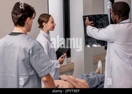 Arzt und Radiologe analysieren medizinische Bilder, einschließlich MRT-Film, um den Zustand des Patienten zu identifizieren, um Behandlungspläne und zukünftige medizinische Untersuchungen zu entwickeln Stockfoto