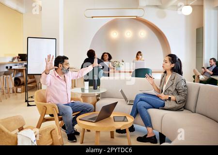 Ein reifer Geschäftsmann, der mit einer Kollegin im Café spricht Stockfoto