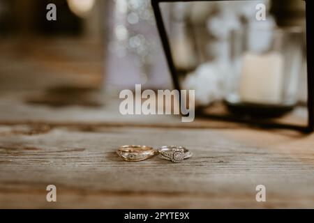 Gold- und Silberhochzeiten mit Diamanten auf einem rustikalen Holztisch Stockfoto