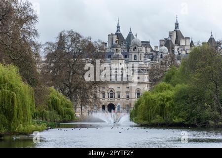 Wunderschöne Aussicht auf Bäume, See, Wasserfontänen und historisches Gebäude Stockfoto