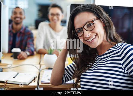 Unser Team ist immer auf dem gleichen Stand. Porträt einer Gruppe junger Büroangestellter, die an ihren Computern sitzen. Stockfoto