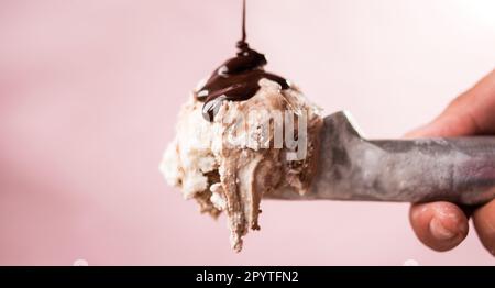Hand hält einen Eislöffel mit Eiscreme Stockfoto