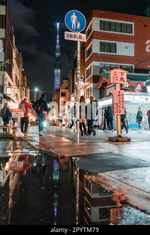 TOKIO, JAPAN - 7. APRIL 2023: Am Abend spazieren die Leute durch den Senso-ji-Tempel in Asakusa und regenregen Stockfoto