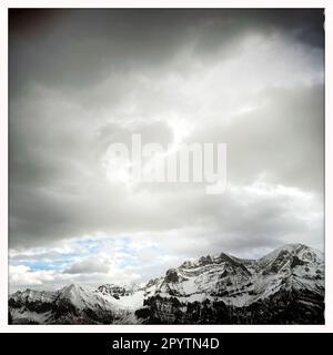 AUS DER SERIE ADELBODEN Mountains in winterlicher Landschaft in Adelboden, Berner Oberland, Kanton Bern, Schweiz. Die malerische Stadt Adelboden ist eine Schweizer Idylle in den Berner Alpen, beeindruckende Gipfel, einzigartige Winterlandschaft, beliebtes Skigebiet, Alpenweiden, Rauschende Wasserfälle, gemütliche Holzhäuser. Aufgrund des Klimawandels und immer weniger Schnee, orientiert sich das klassische Wintersportresort neu, und die Sommersaison gewinnt an Bedeutung. Foto mit iPhone, Hipstamatic App. Stockfoto