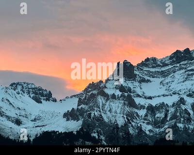 AUS DER SERIE ADELBODEN Mountains in winterlicher Landschaft in Adelboden, Berner Oberland, Kanton Bern, Schweiz. Die malerische Stadt Adelboden ist eine Schweizer Idylle in den Berner Alpen, beeindruckende Gipfel, einzigartige Winterlandschaft, beliebtes Skigebiet, Alpenweiden, Rauschende Wasserfälle, gemütliche Holzhäuser. Aufgrund des Klimawandels und immer weniger Schnee, orientiert sich das klassische Wintersportresort neu, und die Sommersaison gewinnt an Bedeutung. Stockfoto