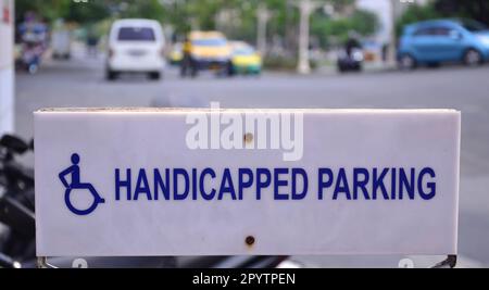 Schild: Behindertenparkplatz in Bangkok, Thailand. Nicht das Sozialmodell der Behinderung: Behinderung durch Barrieren in der Gesellschaft, nicht Behinderung. Stockfoto