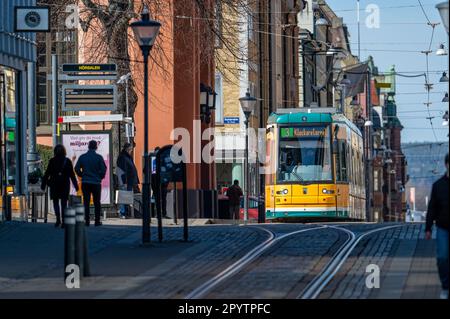 Straßenbahn auf der Hauptstraße Drottningatan im Stadtzentrum von Norrköping, Schweden. Die gelben Straßenbahnen sind berühmt für Norrköping. Stockfoto