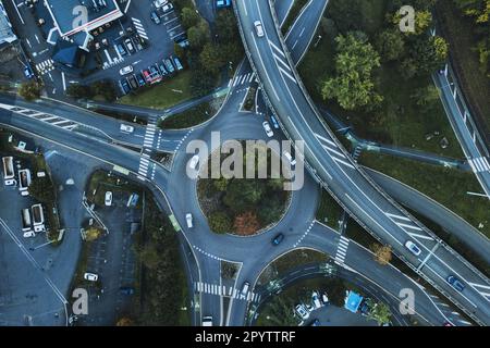 Unvergleichliche Stadtlandschaft mit Autobahn in städtischer Metropole, Blick aus der Vogelperspektive. Autos bewegen sich auf der Straße auf der modernen Schnellstraße. Autobahnkreuzung, Rd Stockfoto