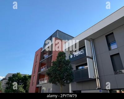 Merci oder danke, Dankbarkeit an die medizinischen Arbeiter während des Covid-19-Ausbruchs, Wort geschrieben auf dem Balkon des Wohngebäudes in Frankreich Stockfoto