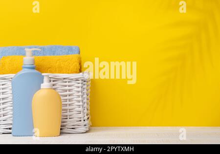 Körperpflegeprodukte und Badhandtücher auf dem Tisch mit Platz für Ihr Produkt oder Ihren Text. Spa-Arrangement Stockfoto