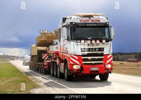 Sisu Polar Hauler Vuorsola zieht im Verkehr eine Überladung eines amerikanischen M1 Abrams Militärpanzers. Konvoi mit 3 Transporten. Aura, Finnland. 28. April 2023. Stockfoto