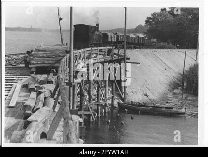 Mit dem Bau des Staudamms durch den Templinsee und dem Bau einer Brücke über die verbleibende Passage für Boote und Schiffe wurde 1956 begonnen, um den Berliner Außenring der Reichsbahn zwischen Saarmund und Golm zu schließen. Eisenbahnlokomotivrahmen, Sandstreuhaufen aus Holz. Historisch. DDR. Foto: MAZ/Herbert Dörries [automatisierte Übersetzung] Stockfoto