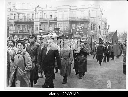 Demonstration am 1. Mai auf dem Platz der Nationen, eine Delegation mit Plakette: G.B. Templiner Siehe Baustelle. Arbeiter der Baustelle am See mit ihnen. Mit dem Bau des Staudamms durch den Templiner See und dem Bau einer Brücke über die verbleibende Passage für Boote und Schiffe wurde 1956 begonnen, um den Berliner Außenring der Reichsbahn zwischen Saarmund und Golm zu schließen. Eisenbahnfoto: MAZ/Herbert Dörries [automatisierte Übersetzung] Stockfoto