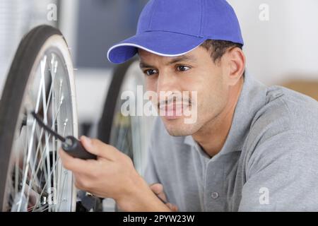 Mann, der ein Rad pumpt Stockfoto
