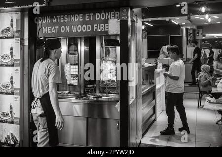 Ein beliebter Döner-Kebab-Laden in Antalya, Türkei, zieht Kunden mit seinen zwei Spießen an Fleisch an, die mit traditionellen Gas- und Holzfeuermethoden zubereitet werden. Einfg Stockfoto