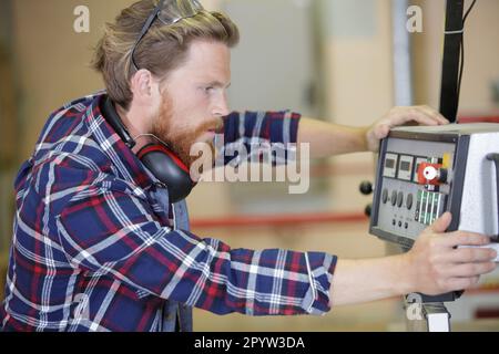 Ein Mann, der Maschinen in der Fabrik bedient Stockfoto