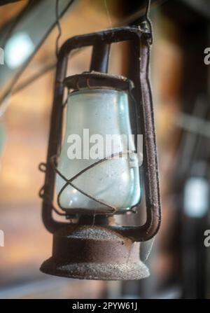 Eine alte Laterne, die in einer Scheune hängt Stockfoto