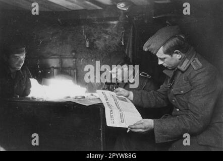 Soldaten auf freien Fuß in einem Wohnbunker in nicht vollständig erobertem Voronesch. Ein Soldat liest die Zeitung Lichtenfelser Tagblatt, eine Sendung von zu Hause. Foto: Müller-Schwanneke. [Maschinelle Übersetzung] Stockfoto