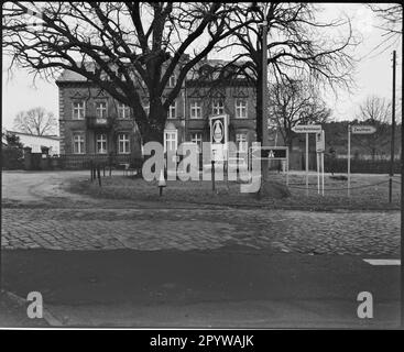 Straßenüberquerung mit Bäumen und Schildern im Winter. Wildau, Bezirk Dahme-Spreewald, Brandenburg. Foto, 1993. Stockfoto