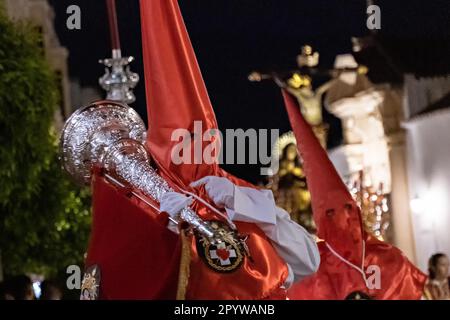 Cofradias mit roten konischen Kapuzen laufen während der Mitternachtsstummprozession am Karfreitag in der Heiligen Woche oder Semana Santa, 6. April 2023 in Ronda, Spanien, durch die Straßen. Ronda, die sich im 6. Jahrhundert v. Chr. niedergelassen hat, hält seit über 500 Jahren Heilige Woche-Prozessionen ab. Stockfoto