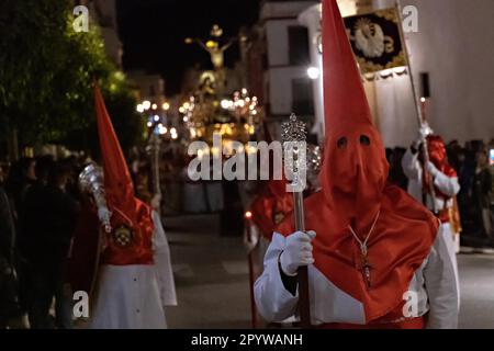 Cofradias mit roten konischen Kapuzen laufen während der Mitternachtsstummprozession am Karfreitag in der Heiligen Woche oder Semana Santa, 6. April 2023 in Ronda, Spanien, durch die Straßen. Ronda, die sich im 6. Jahrhundert v. Chr. niedergelassen hat, hält seit über 500 Jahren Heilige Woche-Prozessionen ab. Stockfoto