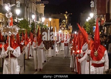 Cofradias mit roten konischen Kapuzen laufen während der Mitternachtsstummprozession am Karfreitag in der Heiligen Woche oder Semana Santa, 6. April 2023 in Ronda, Spanien, durch die Straßen. Ronda, die sich im 6. Jahrhundert v. Chr. niedergelassen hat, hält seit über 500 Jahren Heilige Woche-Prozessionen ab. Stockfoto