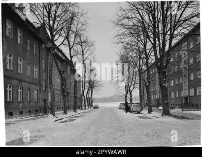 Straße mit Bäumen und Häuser im Winter mit Schnee. Wildau, Bezirk Dahme-Spreewald, Brandenburg. Foto, 1994. Stockfoto