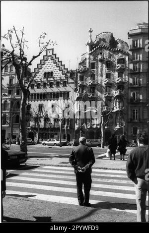 Barcelona (Spanien). Casa Batllo (1877 erbauter Apartmentblock, von Antoni Gaudi in den Jahren 1905-07 umgestaltet). Casa Batllo (rechts), daneben Casa Amatller (1898 erbaut, neue Fassade von Puig i Cadafalch). Davor warten Leute am Zebraübergang. Straßenszene, schwarz-weiß. Foto, 1993. Stockfoto