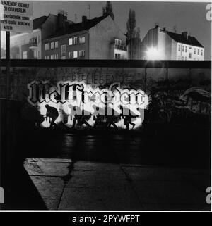 Westberlin, Berliner Mauer, Sektorgrenze (erbaut am 13. August 1961, abgerissen nach dem 9. November 1989). „Art Action Lightning Shadow“ mit Graffiti „World Peace“. Experimentelle Fotografie, 6 x 6 cm Negativ, Schwarzweiß. Foto, 1988. Stockfoto