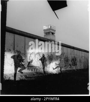 Westberlin, Berliner Mauer, Sektorgrenze (erbaut am 13. August 1961, abgerissen nach dem 9. November 1989). „Art Action Lightning Shadow“ mit Graffiti an der Wand. Experimentelle Fotografie, 6 x 6 cm Negativ, Schwarzweiß. Foto, 1988. Stockfoto