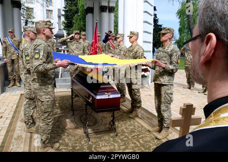 KIEW, UKRAINE - 5. MAI 2023 - Soldaten bedecken den Sarg mit der Leiche des US-Staatsbürgers Christopher James Campbell, einem Soldaten des ukrainischen Auslands Stockfoto