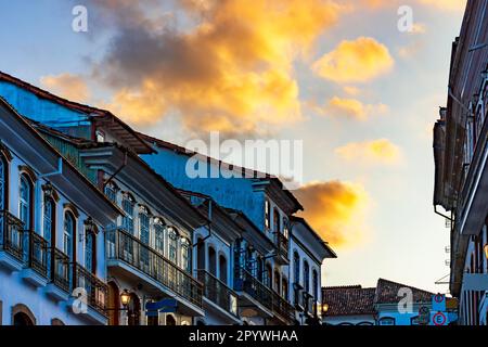 Leuchten und Reflexionen über alten Häusern im Kolonialstil mit Balkonen in der traditionellen historischen Stadt Ouro Preto während des Sonnenuntergangs, Brasilien Stockfoto