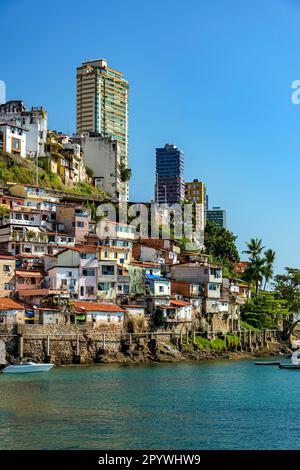 Slum über dem Meer der Stadt Salvador in Bahia mit den Gebäuden im Hintergrund an einem sonnigen Nachmittag, Brasilien Stockfoto