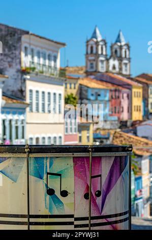 Farbenfrohe Trommel mit dem Viertel Pelourinho mit seinen historischen und bunten Häusern und Kirchen im Hintergrund in der Stadt Salvador, Bahia, Brasilien Stockfoto