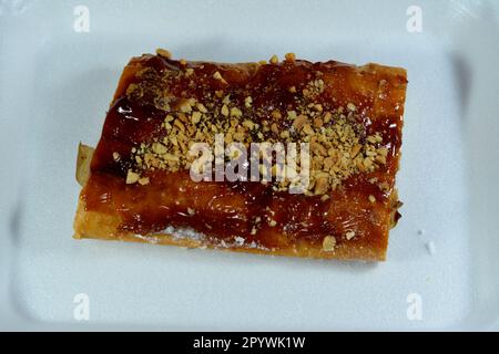 Apfelkuchen gefüllt mit cremigem Apfel, Zimt und süßem Honigsirup und garniert mit Pistazien und Nüssen, köstlicher süßer gebackener Apfelkuchen Stockfoto