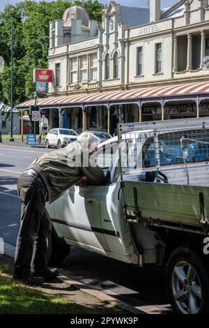 Ein Mann lehnt sich in ein Autofenster, um mit einem Kumpel zu plaudern, Camperdown, Victoria, Australien Stockfoto