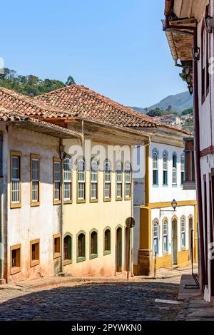 Wunderschöne Straße mit alten bunten Häusern in kolonialer Architektur, Kopfsteinpflaster und Laternen für Beleuchtung, Ouro Preto, Minas Gerais, Brasilien Stockfoto