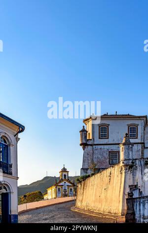 Eingangsstraße zur Stadt Ouro Preto mit Kopfsteinpflaster, Kirchen und historischen Gebäuden aus der Zeit des Imperiums in Brasilien, Brasilien Stockfoto