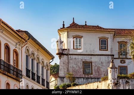 Typische Kolonialarchitektur aus der Zeit des Reiches in der Stadt Ouro Preto in Minas Gerais mit wunderschönem blauen Himmel im Hintergrund, Brasilien Stockfoto