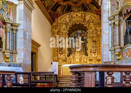 Innenseite und Altar einer alten barocken Kirche mit goldgrünen Wänden in der historischen Stadt Tiradentes in Minas Gerais, Brasilien Stockfoto