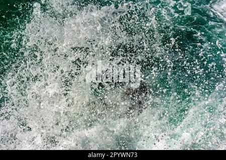 Textur von Wassertropfen, die in die Luft spritzen, wenn Wellen gegen Felsen krachen, Brasilien Stockfoto