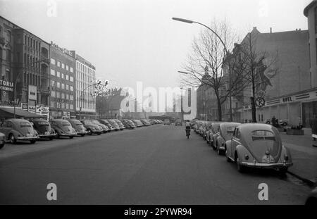 Seit 1953 wird der VW-Käfer mit der ovalen Heckscheibe gebaut. Mehrere VW-Serien stehen in einer Westberliner Straße. Im Hintergrund die Kaiser-Wilhelm-Gedächtniskirche. Unbezahltes Foto um 1953 Uhr. Stockfoto