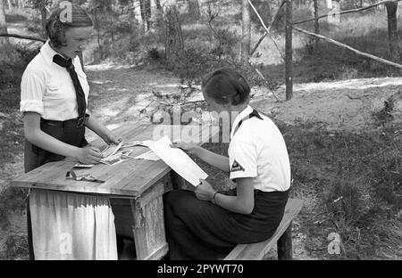 Zwei Briefleserinnen im Sommercamp des Bund Deutscher Maedel in Karlshagen. Unbezahltes Foto von etwa 1937 Stockfoto