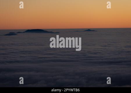 Inseln am Himmel, Monte Terminillo in Sonnenuntergangtönen getaucht. Stockfoto