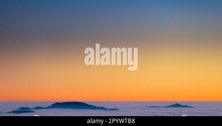 Inseln am Himmel, Monte Terminillo in Sonnenuntergangtönen getaucht. Stockfoto