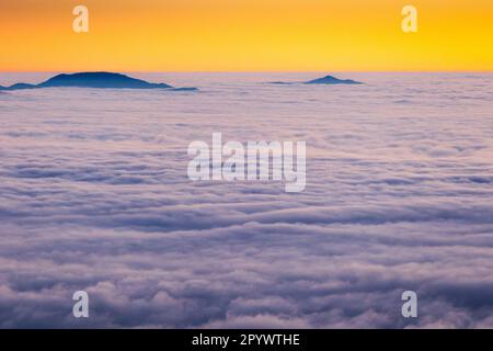 Inseln am Himmel, Monte Terminillo in Sonnenuntergangtönen getaucht. Stockfoto