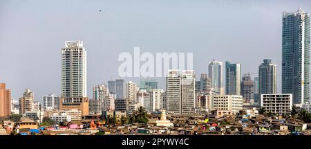 Moderne Skyline mit Wolkenkratzern, vor den gewellten Eisenhütten eines Slums in Mumbai, Indien Stockfoto