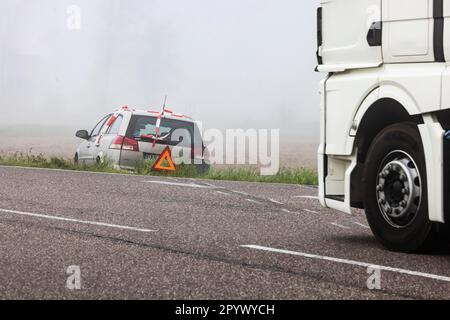 Ein Auto auf einer Wiese, ein Unfall mit Warndreieck, Bremsspuren zeigen, dass das Fahrzeug die Landstraße Rheinmünster, Baden-Württemberg verlassen hat Stockfoto